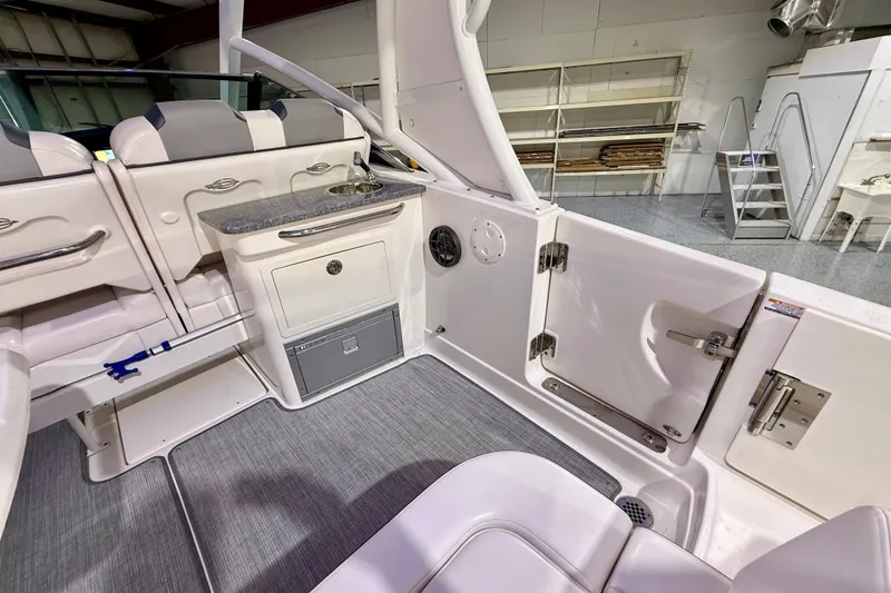 Slide: The Image of 2021 Chaparral 280 OSX boat interior with seating, sink, and storage compartments. - 22