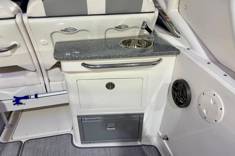 Slide: The Image of 2021 Chaparral 280 OSX boat interior with sink, countertop, and storage. - 23