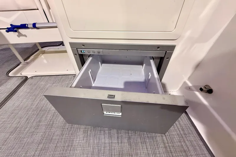 Slide: The Image of Open storage drawer on 2021 Chaparral 280 OSX boat, showcasing interior space. - 24