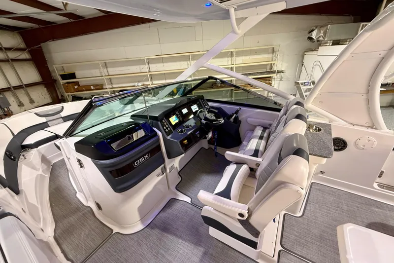 Slide: The Image of 2021 Chaparral 280 OSX boat interior with modern helm and seating in a showroom. - 30