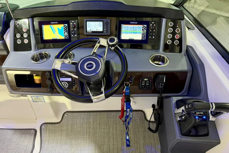 Slide: The Image of 2021 Chaparral 280 OSX boat dashboard with steering wheel and navigation displays. - 34