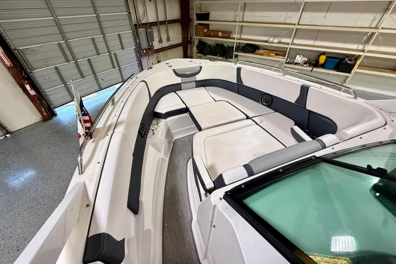 Slide: The Image of 2021 Chaparral 280 OSX boat interior with spacious seating in a garage setting. - 37