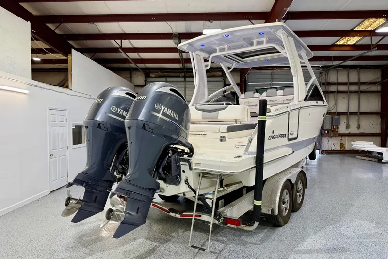 Slide: The Image of 2021 Chaparral 280 OSX boat with dual Yamaha engines in a spacious indoor storage facility. - 4