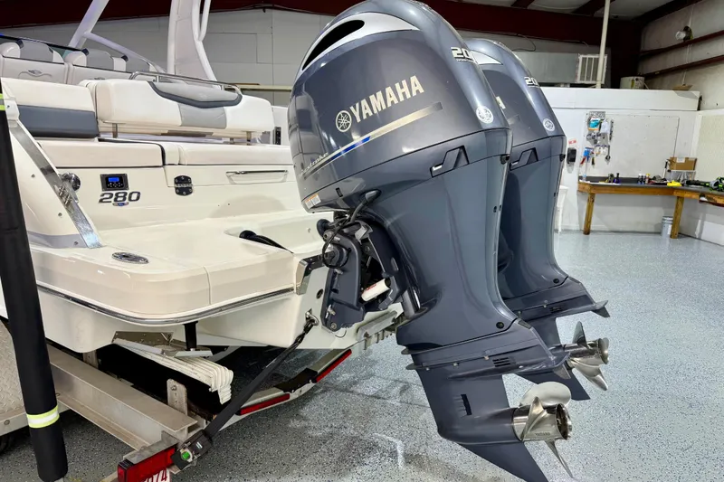 Slide: The Image of 2021 Chaparral 280 OSX boat with dual Yamaha outboard engines in a garage setting. - 7