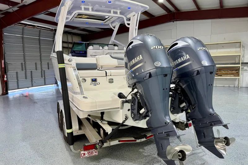 Slide: The Image of 2021 Chaparral 280 OSX boat with dual Yamaha 200 engines in a garage setting. - 8