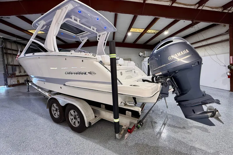 Slide: The Image of 2021 Chaparral 280 OSX boat with Yamaha engine in a garage setting. - 9