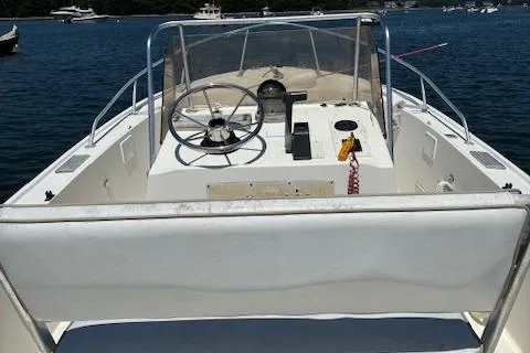 Slide: The Image of 1989 Mako 191CC boat interior with steering wheel, docked on calm water. - 3