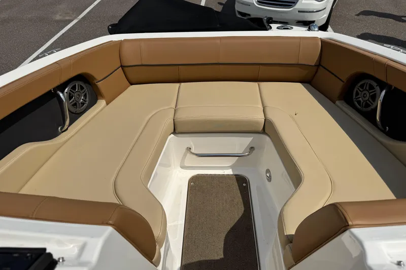 Slide: The Image of 2014 Sea Ray 220 Sundeck Outboard interior with tan seating and speakers. - 18