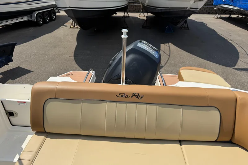 Slide: The Image of 2014 Sea Ray 220 Sundeck Outboard boat with tan seating and visible outboard motor. - 21