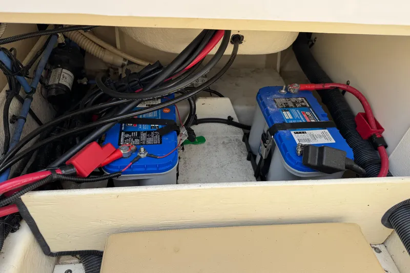 Slide: The Image of Battery compartment of a 2014 Sea Ray 220 Sundeck Outboard boat, showing wiring and connections. - 23