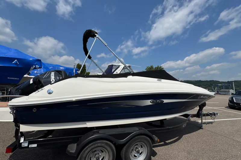 Slide: The Image of 2014 Sea Ray 220 Sundeck Outboard boat on trailer under blue sky. - 3