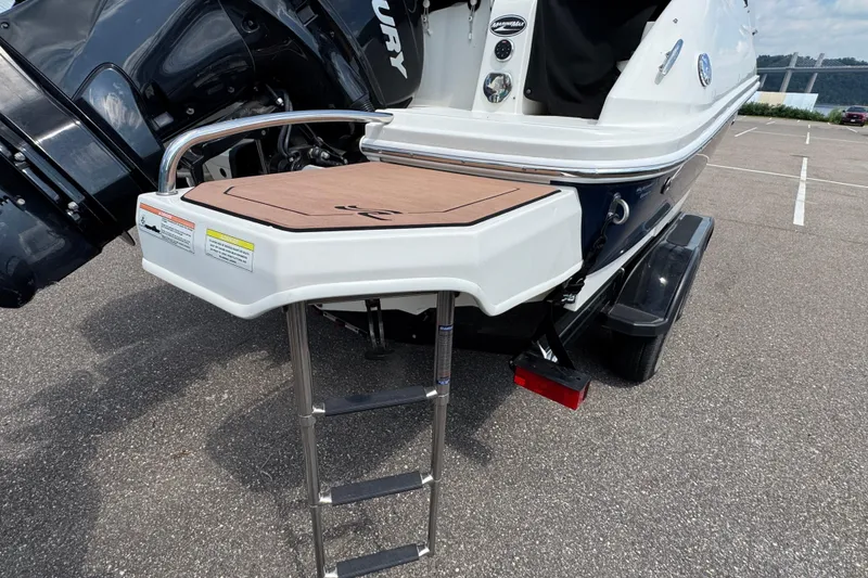 Slide: The Image of 2014 Sea Ray 220 Sundeck Outboard with swim platform and ladder in parking lot. - 7