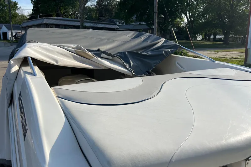 Slide: The Image of 2007 Glastron MX 175 boat with partially covered seating, parked outdoors. - 4