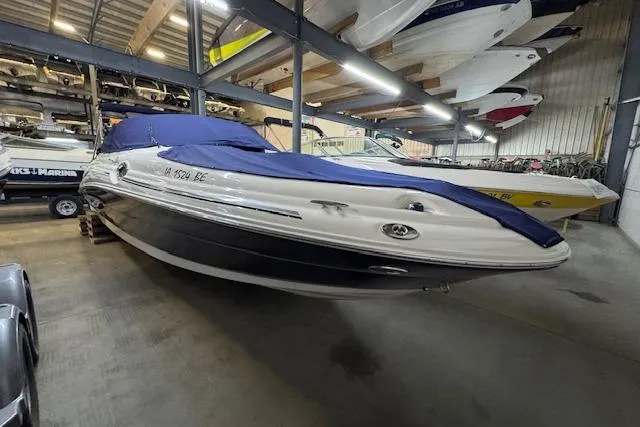 The Image of 2006 Sea Ray SDX 270 boat in indoor storage with blue cover. - 1