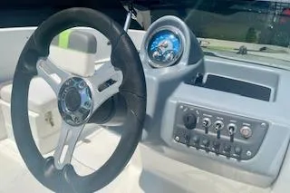 Slide: The Image of Steering wheel and dashboard of 2021 Tahoe T16 boat, featuring modern controls and gauges. - 2