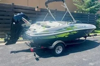 Slide: The Image of 2021 Tahoe T16 boat on trailer, parked outdoors, featuring sleek design and vibrant colors. - 4