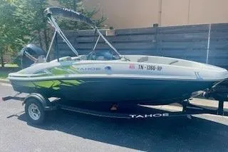 Slide: The Image of 2021 Tahoe T16 boat on trailer, parked outdoors in sunlight. - 6