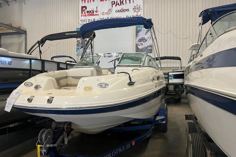 The Image of 2005 Chaparral 216 SSi boat displayed indoors on a trailer. - 1