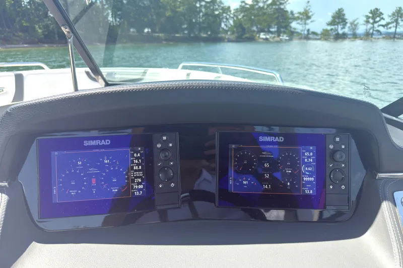 Slide: The Image of 2024 Chaparral 26 Surf boat dashboard with dual Simrad displays on a sunny day. - 9