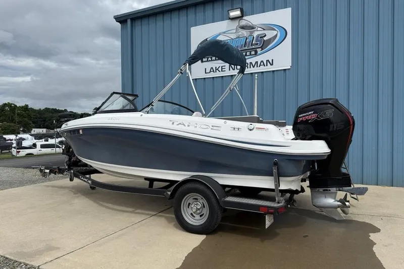 Slide: The Image of 2019 Tahoe 450 TS boat on trailer, parked outside marine center. - 10