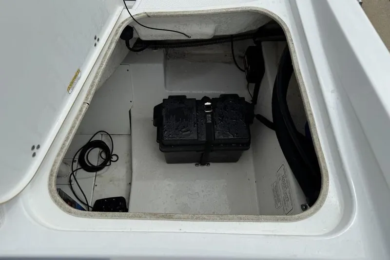 Slide: The Image of Open storage compartment in 2019 Tahoe 450 TS boat with battery and cables. - 21
