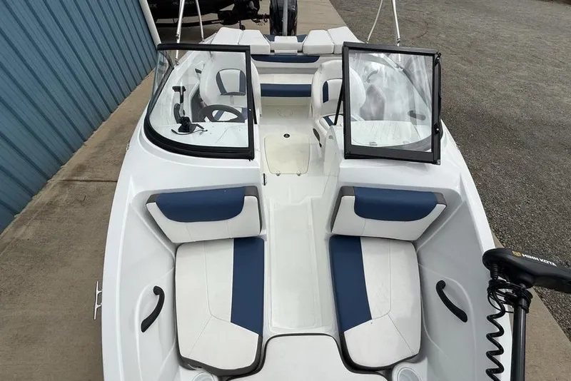 Slide: The Image of 2019 Tahoe 450 TS boat with blue and white seating, open windshield, and trolling motor. - 25