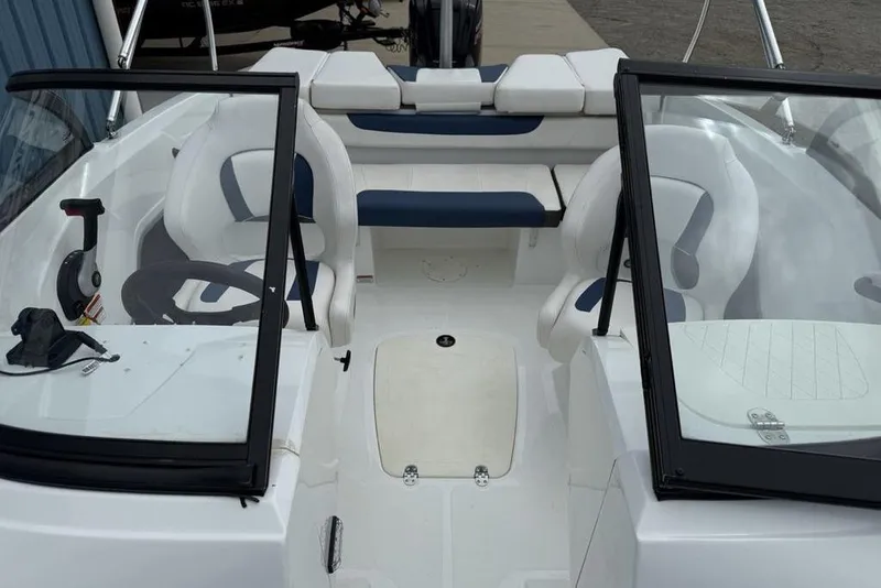 Slide: The Image of 2019 Tahoe 450 TS boat interior with white and blue seating, steering wheel, and windshield. - 4