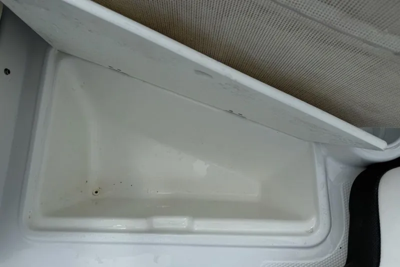 Slide: The Image of Open storage compartment in 2019 Tahoe 450 TS boat, featuring a white interior. - 5