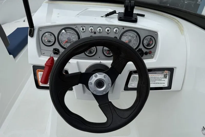 Slide: The Image of Steering wheel and dashboard of 2019 Tahoe 450 TS boat, featuring gauges and controls. - 8
