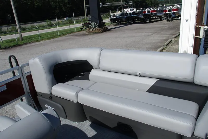 Slide: The Image of 2026 Sun Tracker SportFish 20 DLX pontoon boat with comfortable seating in a parking area. - 11