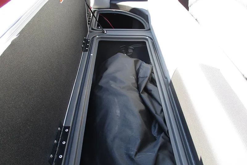Slide: The Image of 2026 Sun Tracker SportFish 20 DLX storage compartment with black cover inside. - 13