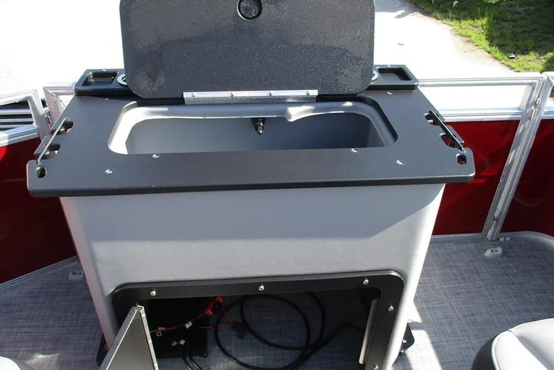 Slide: The Image of 2026 Sun Tracker SportFish 20 DLX boat with open storage compartment and sleek design. - 24