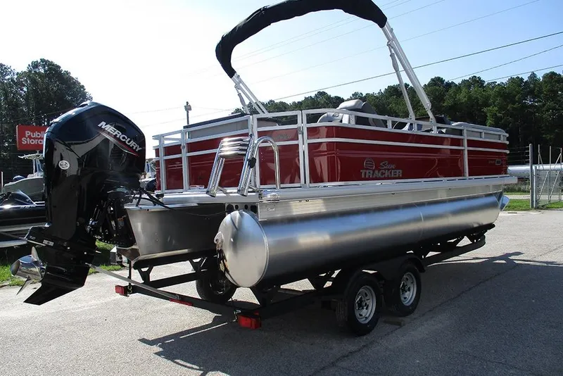 Slide: The Image of 2026 Sun Tracker SportFish 20 DLX pontoon boat on trailer, featuring Mercury outboard motor. - 7