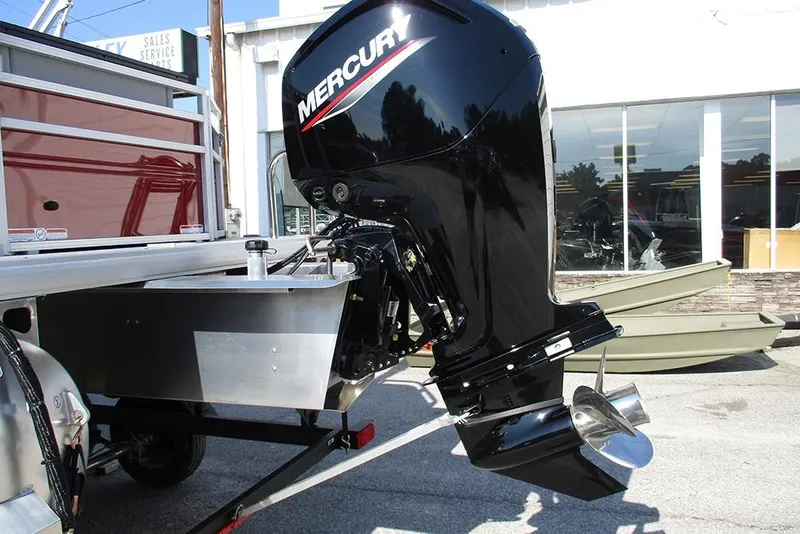 Slide: The Image of 2026 Sun Tracker SportFish 20 DLX with Mercury outboard motor, displayed outdoors. - 9