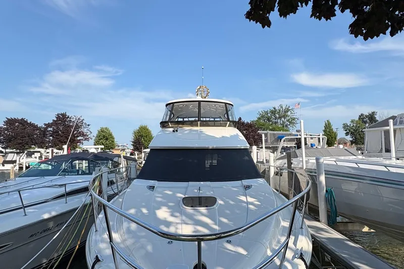 Slide: The Image of 2015 Meridian 441 Sedan yacht docked at marina under clear blue sky. - 2