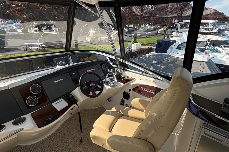 Slide: The Image of 2015 Meridian 441 Sedan helm with Raymarine electronics, beige captain's chair, marina view. - 3