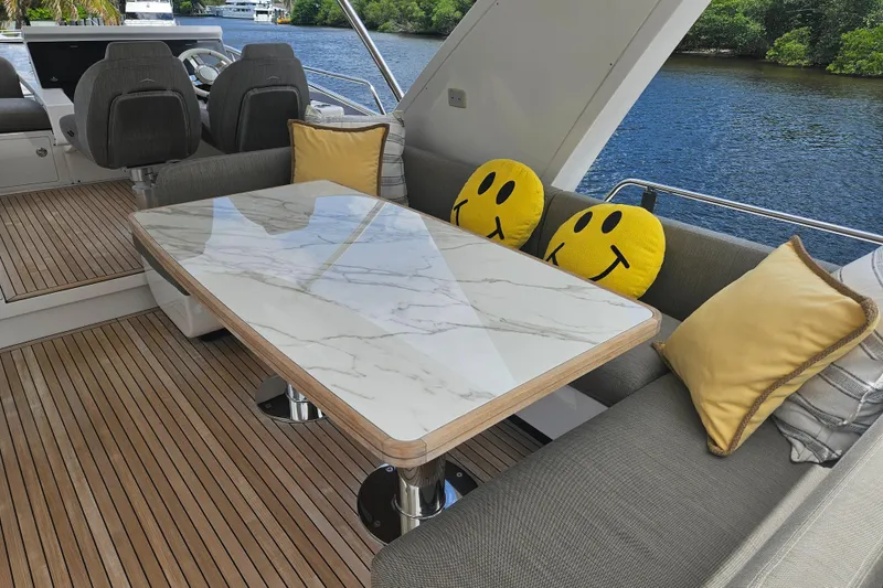 Slide: The Image of Luxurious Azimut 66 yacht interior with marble table, smiley cushions, and river view. - 12