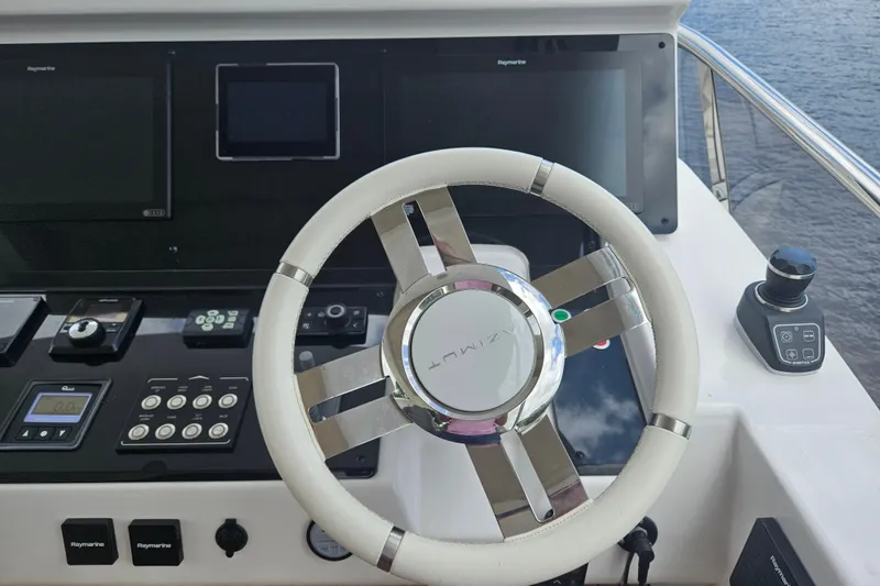 Slide: The Image of Steering wheel and controls of 2022 Azimut 66 yacht, featuring advanced navigation systems. - 18