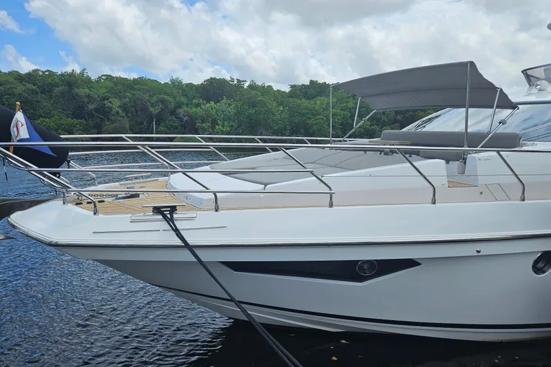 Slide: The Image of Azimut 66 yacht 2022 model docked by lush greenery under a cloudy sky. - 4