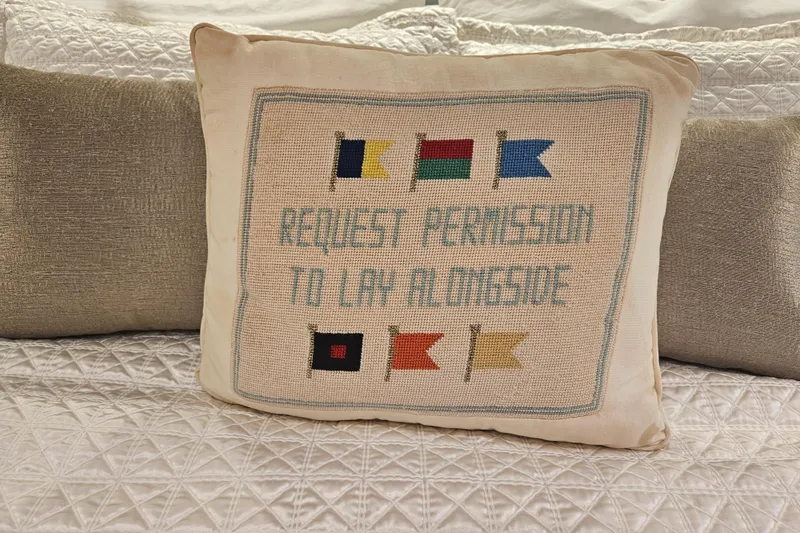 Slide: The Image of Decorative pillow with nautical flags and "Request Permission to Lay Alongside" text. - 53