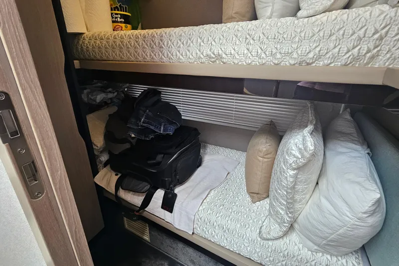 Slide: The Image of Bunk beds in 2022 Azimut 66 yacht cabin with luggage and pillows. - 57