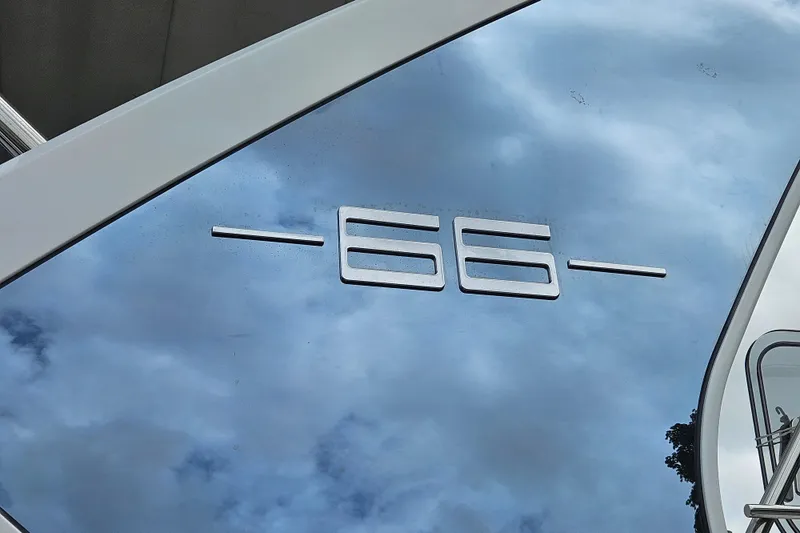 Slide: The Image of Reflective surface with "66" emblem on 2022 Azimut yacht, under cloudy sky. - 7
