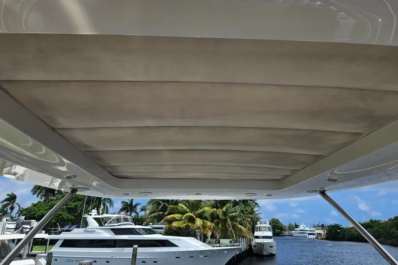 Slide: The Image of 2022 Azimut 66 yacht with covered deck, docked near palm trees and waterway. - 8