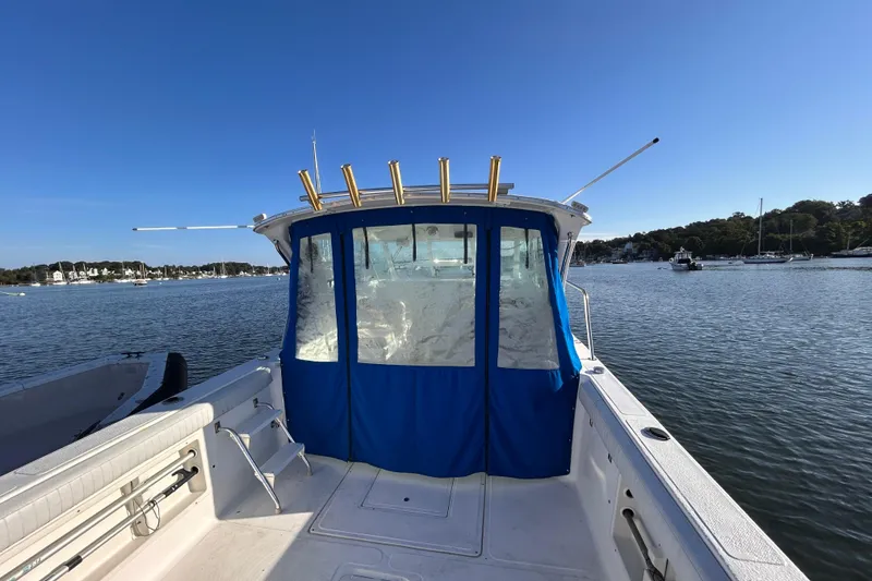 Slide: The Image of 2011 Baha Cruisers 277 GLE boat on calm water, blue canopy, sunny day. - 10