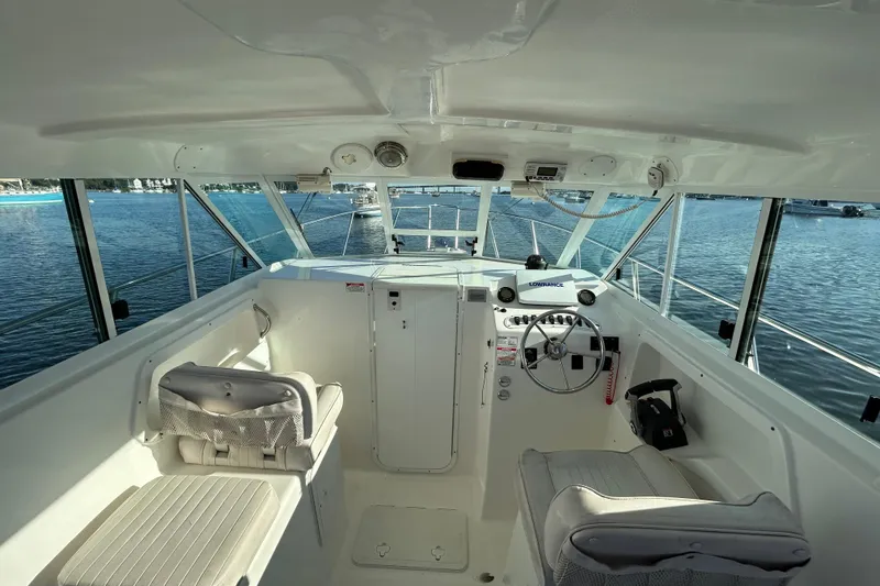 Slide: The Image of 2011 Baha Cruisers 277 GLE boat interior with steering wheel and seating on calm water. - 13