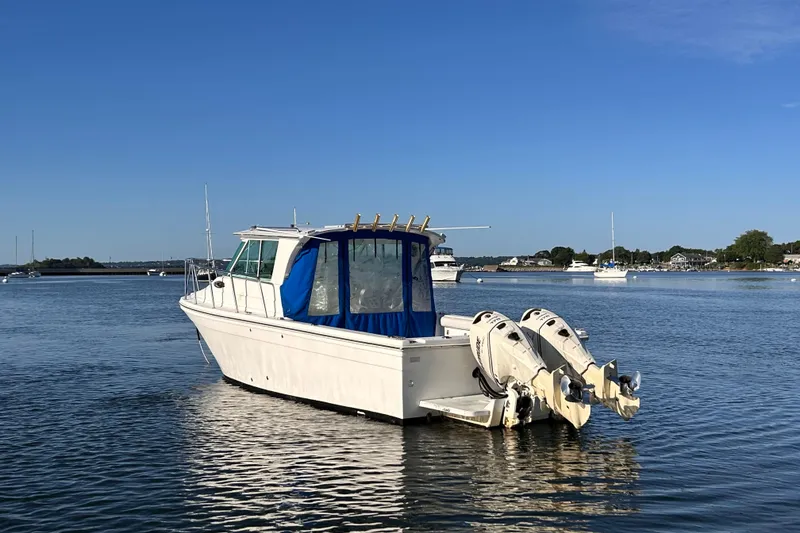 Slide: The Image of 2011 Baha Cruisers 277 GLE boat on calm water with blue canopy. - 6