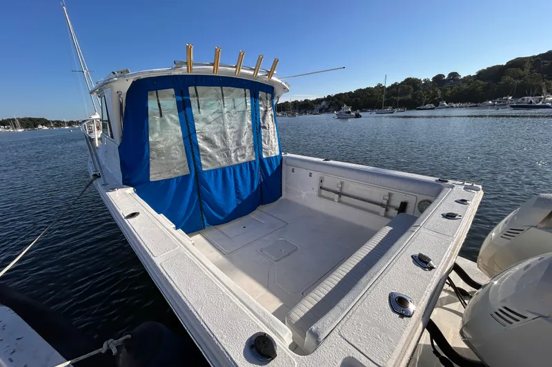 Slide: The Image of 2011 Baha Cruisers 277 GLE boat docked, featuring spacious deck and blue canopy. - 8