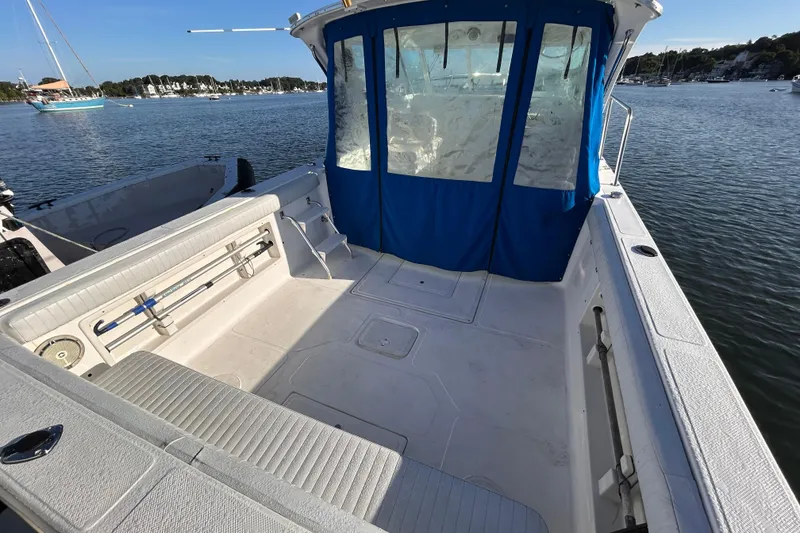 Slide: The Image of 2011 Baha Cruisers 277 GLE boat with spacious deck and blue canopy on calm water. - 9