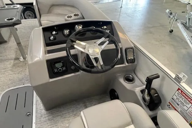 Slide: The Image of 2025 Bennington L22 boat interior with steering wheel, control panel, and seating. - 5
