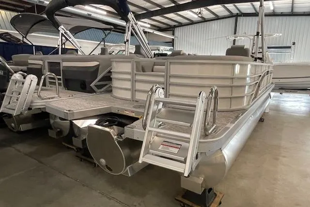 Slide: The Image of 2025 Bennington L22 pontoon boat in a showroom, featuring a sleek design and sturdy ladder. - 6